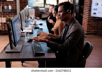 Customer service support employee working at call center, helping clients on telephone helpline. Telemarketing operator answering call from people to give remote assistance at helpdesk.