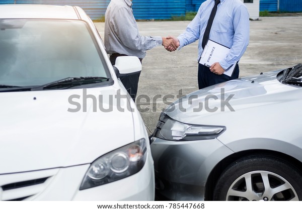 Customer shake hand with auto insurance agents\
after agreeing to terms of\
insurance.