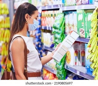 Customer, Shopper And Consumer Reading Label For Nutritional Ingredients On Products, Stock And Groceries While Shopping In Supermarket Store In Covid Pandemic. Woman Deciding Choice To Buying Food