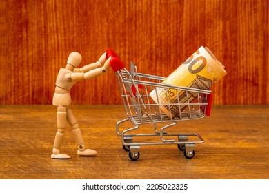 Customer With Shopping Cart. Let's Go Shopping! Wooden Dummy Pushing Shopping Cart With A Money Roll. 