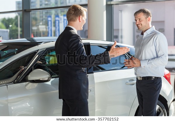 Customer is smiling to his\
car dealer 