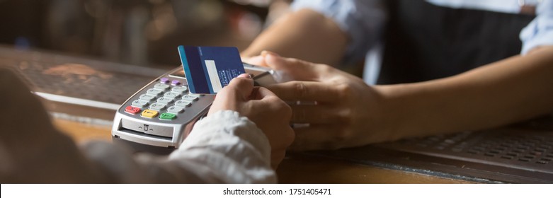 Customer stand near bar counter make payment use contactless credit card close up hands device view, cashless method pay bills in commercial places concept. Horizontal banner for website header design - Shutterstock ID 1751405471