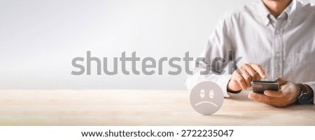 Customer submits negative feedback, expressing unhappiness bad experience, giving low satisfaction rating via mobile phone, sad face icon shows poor service review.