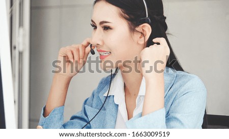 Customer support agent or call center with headset works on desktop computer while supporting the customer on phone call. Operator service business representative concept.