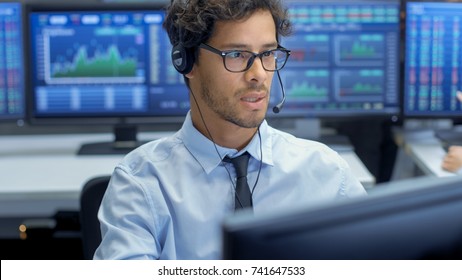 Customer Support Service Representative Talks with a Client Through Headset. He's Working in a Big Technical Consulting Company.