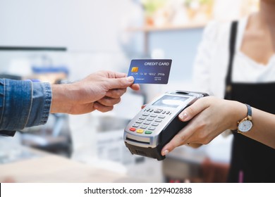 Customer using credit card for payment to owner at cafe restaurant, cashless technology and credit card payment concept - Shutterstock ID 1299402838