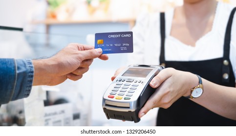 Customer using credit card for payment to owner at cafe restaurant, cashless technology and credit card payment concept