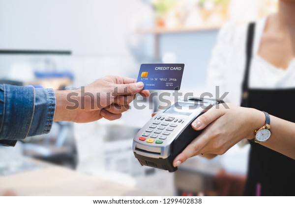 Customer using\
credit card for payment to owner at cafe restaurant, cashless\
technology and credit card payment\
concept