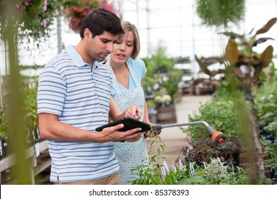 Customer using a digital tablet in greenhouse - Powered by Shutterstock