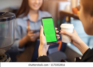 Customer Using Her Smartphone And Nfs High Technology To Pay A Barista For Her Purchase With Phone, Mobile Payment, Online Shop At Coffee Cafe.