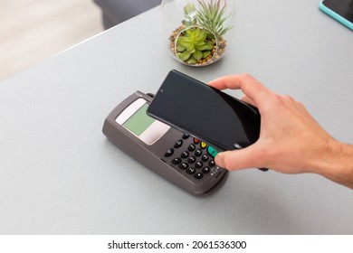 Customer using mobile phone to pay by NFC