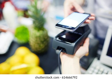 Customer using modern media technologies to make payment in supermarket - Powered by Shutterstock