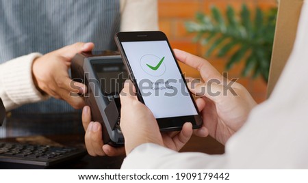 Customer using phone for payment at cafe restaurant, cashless technology and money transfer concept