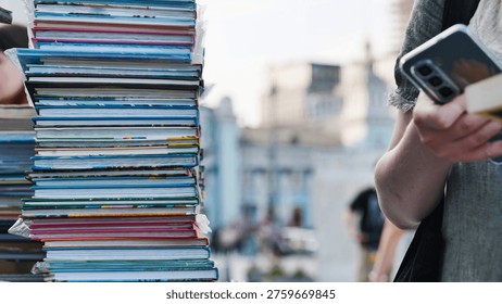 Customer using phone while browsing books at an outdoor book market