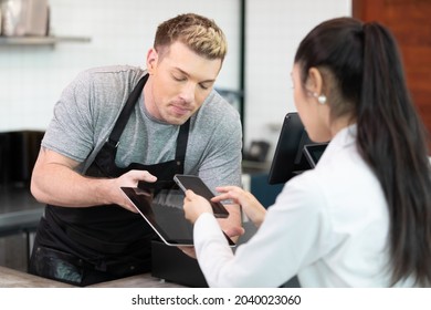 Customer Using Smartphone Scan QR Payment Code For Coffee Drink, From Barista Staff At The Counter In Cafe Or Coffee Shop