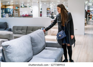 Customer woman buying new furniture - sofa or couch in a store supermarket mall store