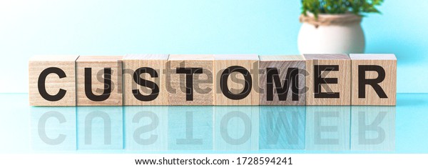 CUSTOMER word\
from wooden blocks with letters, to divide or use something with\
others share concept, blue\
background