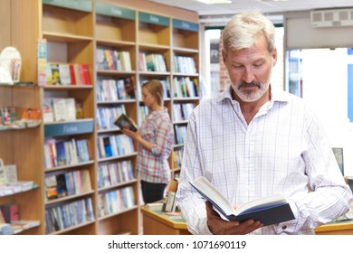 Customers Browsing Books In Bookshop