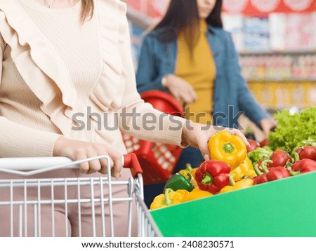 Customers buying vegetables in the produce section at the grocery store, fresh food and grocery shopping concept