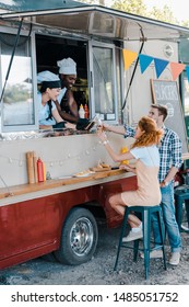 Customers Clinking Beer With Multicultural Chefs In Food Truck 