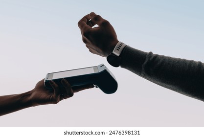 Customer's hand paying a bill with a smartwatch, tapping to pay at a contactless point of sale. Man completing a convenient and secure electronic transaction using NFC technology. - Powered by Shutterstock