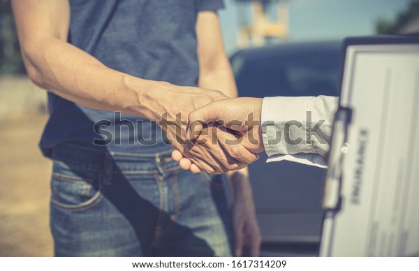 Customers\
shake hand with car insurance agents to enter into friendly terms\
and conditions, Car crash on the road\
concept.
