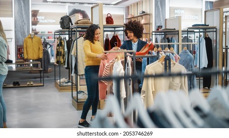 Customers Shopping In Modern Clothing Store, Retail Sales Associate Assists Client. Diverse People In Fashionable Shop, Choosing Stylish Clothes, Colorful Brand Designs, Quality Sustainable Materials.