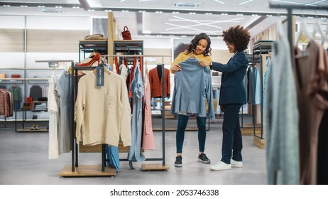 Customers Shopping In Modern Clothing Store, Retail Sales Associate Assists Client. Diverse People In Fashionable Shop, Choosing Stylish Clothes, Colorful Brand Designs, Quality Sustainable Materials.