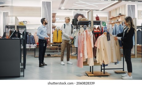 Customers Shopping In Modern Clothing Store, Retail Sales Associate Assists Clients. Diverse People In Fashionable Shop, Choosing Stylish Clothes, Colorful Brand Designs, Quality Sustainable Materials