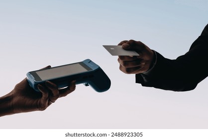 Customers use contactless payment technology at a modern checkout. Hands hold bank and credit cards to tap and pay using a card reader machine. Enjoy the convenience of this cashless transaction. - Powered by Shutterstock