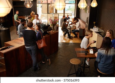 Customers Waiting At Counter In A Busy Modern Coffee Shop