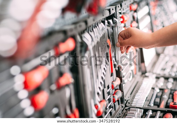 Customers or worker (builder, repairman,\
handyman) at the store chooses wrench instrument (tools). Display\
of tools shop marketing for home and auto\
repair