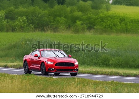 Customized red roadster driving on asphalt highway