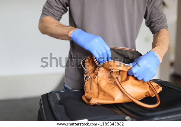 A\
Customs at airport doing security check of hand\
baggage