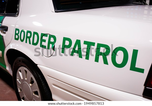 Customs and Border patrol logo on the side of the\
white patrol car