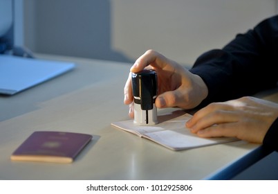 Customs Officer Stamping a Travelling Passport