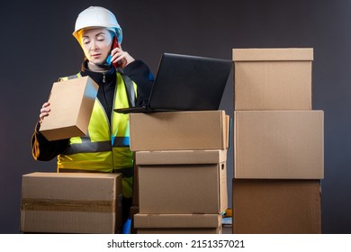 Customs processing of goods. Woman employee of customs center. Girl with box is talking on phone. Woman is engaged in customs processing. Concept checking goods at state border. Girl in yellow vest