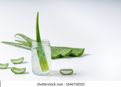 Cut aloe vera stem and gel in wooden bowl on white background, healthy food drink and skin care for beauty concept, copy space