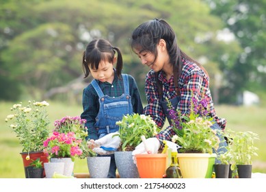 Cut Asian Little Girl With Woman Planting  Flowers Tree In Pots At Garden Outdoor.Child Education Of Nature.caring For New Life.Save Earth Holiday Environment Day Ecology Concept 
