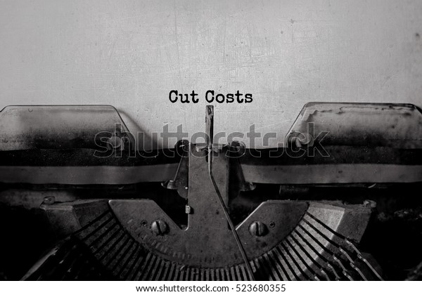 Cut Costs typed\
words on a vintage\
typewriter