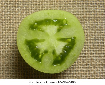 Cut cross section detail of green fresh unripe tomato