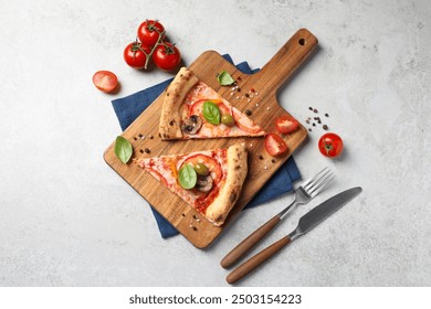 Cut delicious vegetarian pizza, cutlery and ingredients on light grey table, top view - Powered by Shutterstock