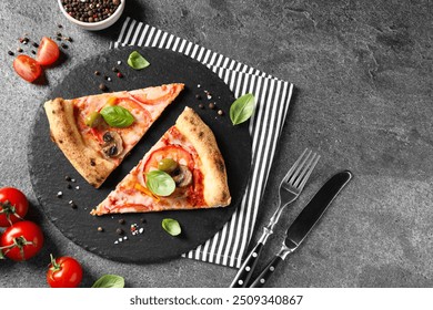 Cut delicious vegetarian pizza, cutlery and ingredients on grey table, top view. Space for text - Powered by Shutterstock