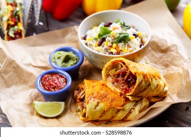 cut food burrito on paper with salad and sauces