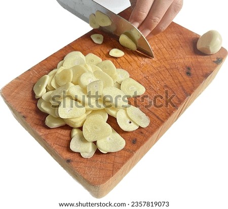 Cut garlic on wooden chopping block on white background, Chopping Garlic on Wooden Board Using Sharp Knife, Preparation in the Kitchen Making Delicious Recipe