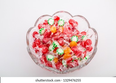 A Cut Glass Bowl Full Of Various Wrapped Candies And Mints