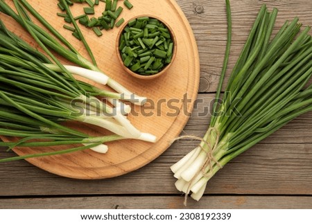 Cut green onion on grey wooden background. Top view