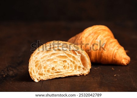 Cut in Half Croissant with Inside Texture and Thin Crisp Layers. Delicious French Pastry. Dark background.