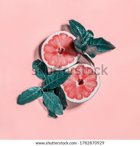 Cut in half grapefruit with leaves. Two halves on bright pink background. Square cropping. Raw eating diet concept. Super natural food