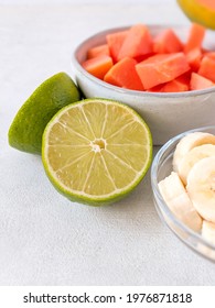 Cut Lime With Banana Slices And Papaya Chunks In Bowls. Fresh Fruit.